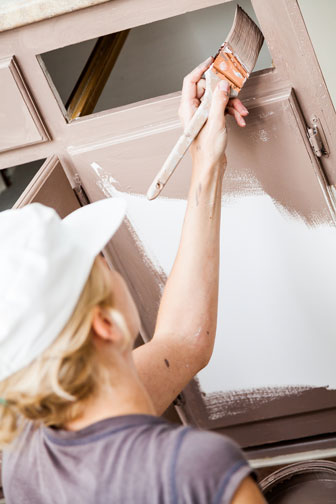 woman painting a kitchen cabinet